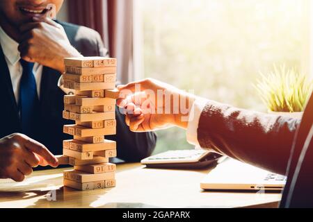 Two business man strategy risk, pulling block wood building tower Stock Photo