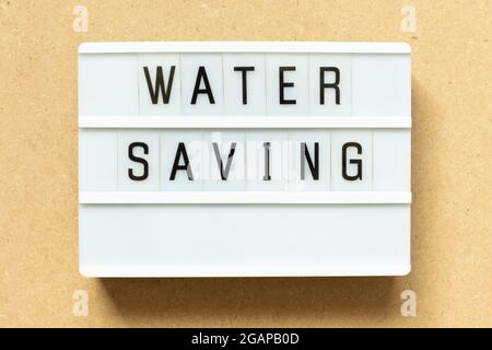 Lightbox with word water saving on wood background Stock Photo