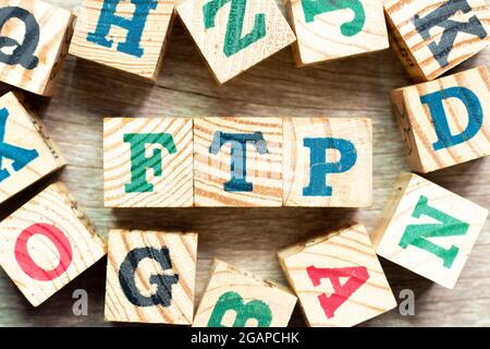 Alphabet letter block in word FTP (Abbreviation of File Transfer Protocol) with another on wood background Stock Photo