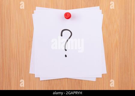 White Sticky Notes with Question Mark Pinned to the Wooden Message Board. To Do List Reminder in the Office. Memo Note at Work Stock Photo