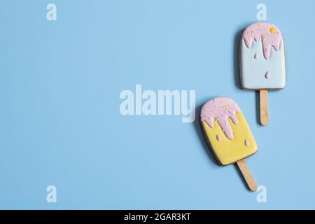 Background with festive gingerbread cookies in the form of ice cream on a stick, covered with glaze copy space. Stock Photo