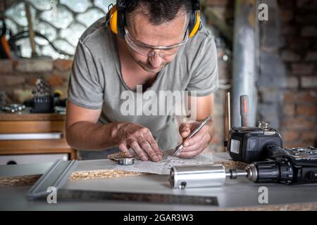 Joiner in the process of work, measurements, drilling accuracy. Stock Photo