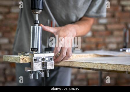 The carpenter works as a professional tool for drilling wood. Stock Photo