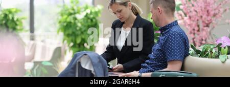 Man and woman in the hotel lobby looking at information on laptop Stock Photo