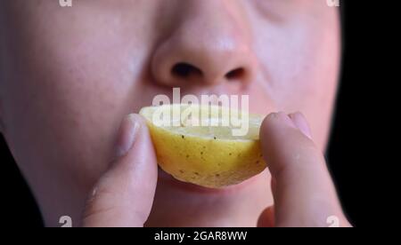 Southeast Asian, Chinese and Myanmar young man with cold flu gets loss of smell called anosmia. He smells scent of lemon while staying at home. Front Stock Photo