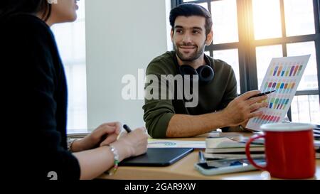 Young designer or creative man giving some new ideas about project to his partners meeting room. Business people discussing over new business project Stock Photo