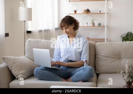 Beautiful young woman using computer at home. Stock Photo