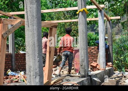 Man at work carrying sand on the construction site. Stock Photo