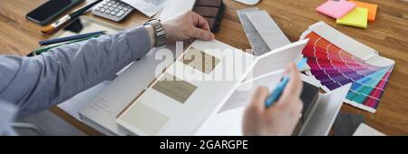Male designer chooses flooring pattern for home closeup Stock Photo