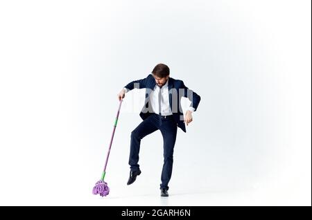 business man in a suit with a mop in his hands providing services cleaning floors Stock Photo