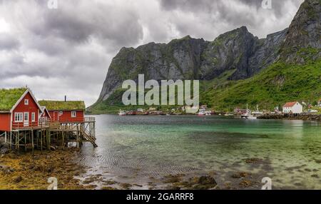 Moskenes, Norway - 20 July, 2021: colorful red wooden houses on stilts in the fjord in Moskenes in the Lofoten Islands of Norway Stock Photo