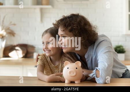 Head shot dreamy smiling mother and little daughter planning future Stock Photo