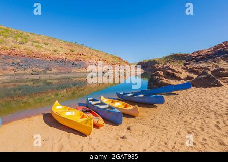 Colourful kayaks lined up on the sandy beach at Dimond Gorge, Mornington Wilderness Camp, Kimberley Region, Western Australia, WA, Australia Stock Photo