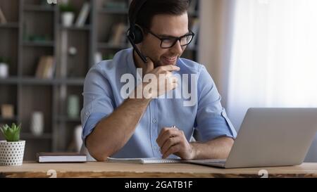 Young male student in headset confer with teacher online Stock Photo