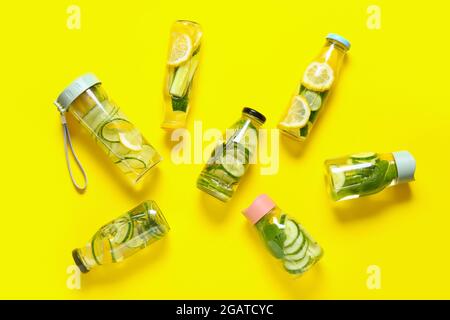 Bottles with cucumber lemonade on color background Stock Photo