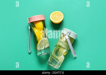 Bottles with cucumber lemonade on color background Stock Photo