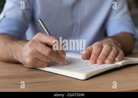 Young male hands hold pencil take notes to paper copybook Stock Photo