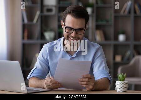 Happy young businessman enjoy reading good news in paper letter Stock Photo