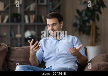 Young man professional expert talk by videocall using headset phone Stock Photo