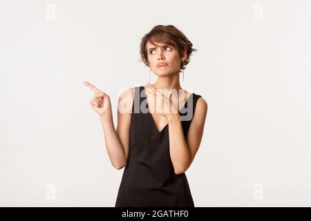 Image of silly disappointed woman in black dress looking unamused ...