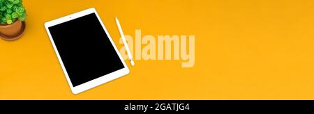 Banner workspace white tablet with black screen mockup on a yellow bright background office desk concept design with copy space, flat lay composition Stock Photo