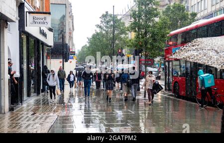 Pic shows: Wet weather battered shoppers in Oxford Street on Saturday afternoon as the rainy July continued to the very last day of the month  31.7.21 Stock Photo