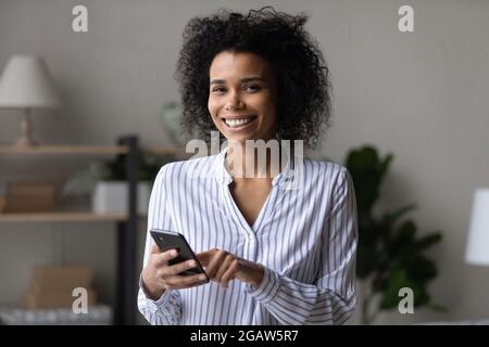 Portrait of smiling African American woman use cellphone Stock Photo
