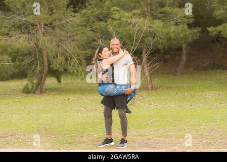 Fitness couple hugging looking at the camera in the park Stock Photo
