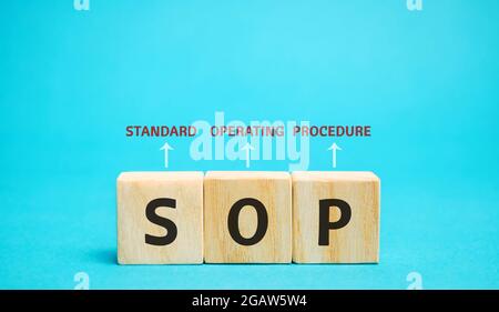 Wooden blocks with the word SOP ( Standard operating procedure ). Instructions to assist employees in complex routine operations. Business concept Stock Photo