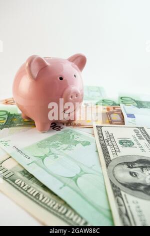 Pig shaped piggy bank, euro banknotes and us dollars on isolated white background Stock Photo