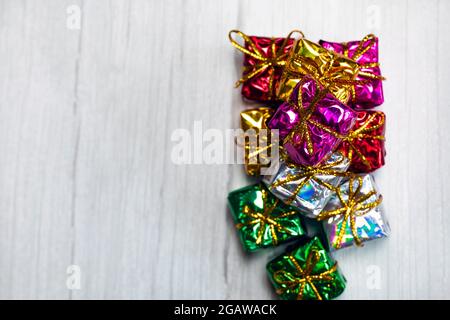 Pile of colored shiny gift boxes with copy space on white wood background,modern retro Christmas design, Colorful presents,Holiday concept Stock Photo