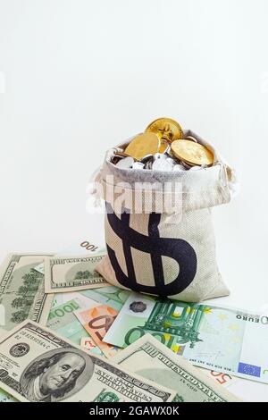 pouch with coins and bitcoins on us dollar and euro banknotes Stock Photo