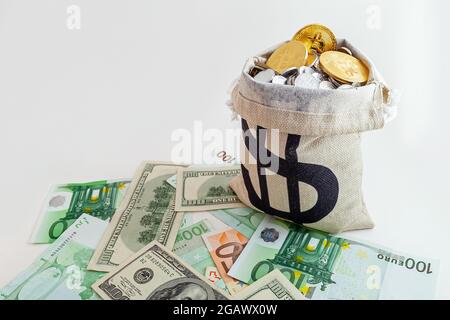 pouch with coins and bitcoins on us dollar and euro banknotes Stock Photo