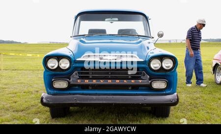 Front end of an old rustic Chevrolet truck in the grass with some