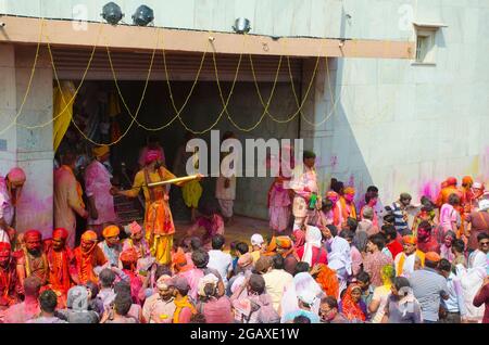 Pilgrims and priests are playing colors in a temple in Mathura, India