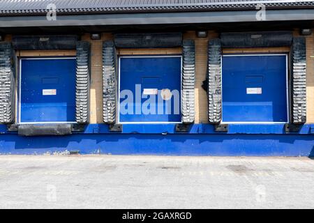 Row of loading docks with closed doors at an industrial warehouse. Stock Photo