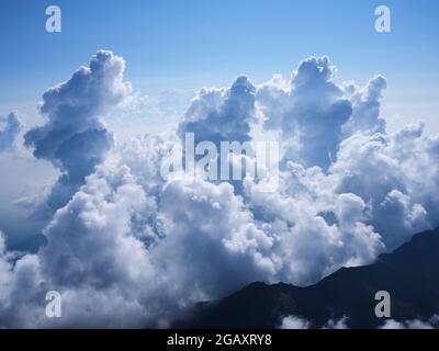 AERIAL VIEW. Towering cumulus clouds reaching about 4000 meters above the Po Plain east of Monte Viso. Province of Cuneo, Piedmont, Italy. Stock Photo