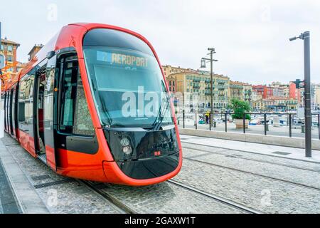 Nice, France - 11. 03. 2021 Modern red electric tram for passengers rolling through the streets on the old port of Nice. High quality photo Stock Photo