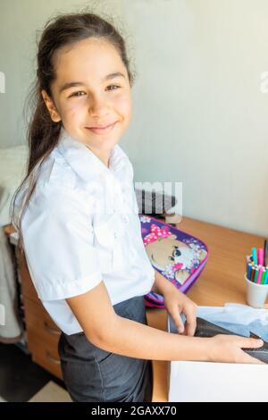 A schoolgirl holds a new shoe in her hands Stock Photo