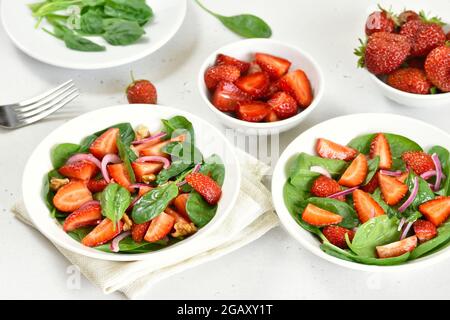 Healthy breakfast with fruit salad from strawberry, spinach and walnut in bowl Stock Photo