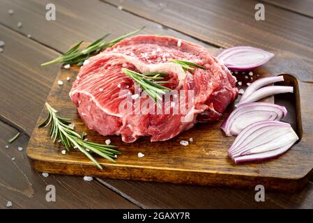 Raw beef steak on cutting board, close up view Stock Photo