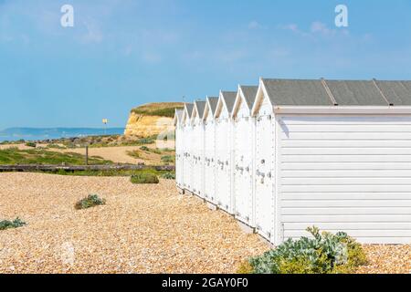 row of white wood beach huts in St Leonards on Sea, East Sussex Stock Photo