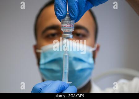 A NHS health worker prepares to administer the Moderna Covid-19 vaccine to a member of public in a vaccination centre in London. Stock Photo