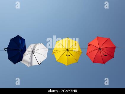 Colourful umbrellas hang on a rope between houses above the pedestrian zone of Bad Kreuznach, Rhineland-Palatinate, Germany. Stock Photo