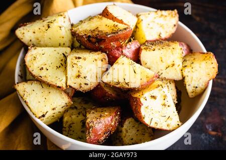 Tuscan Roasted Red Potatoes in a Serving Bowl: Roasted red potatoes coated in olive oil, spices, and garlic Stock Photo
