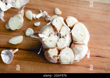 Trimmed Head of Garlic on a Bamboo Cutting Board: A head of garlic that has had the ends trimmed off for roasting Stock Photo