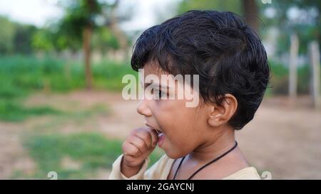 Portrait of Indian cute girl with deep black eyes in sunny park Stock Photo