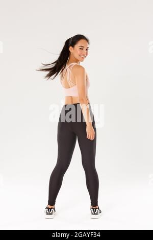 Full length of active and healthy good-looking asian fitness girl,  sportswoman turn behind at looking at camera with satisfied face, gym coach  Stock Photo - Alamy