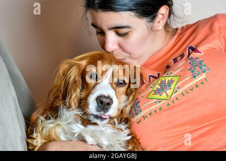 Young woman kissing a cute dog pet Stock Photo