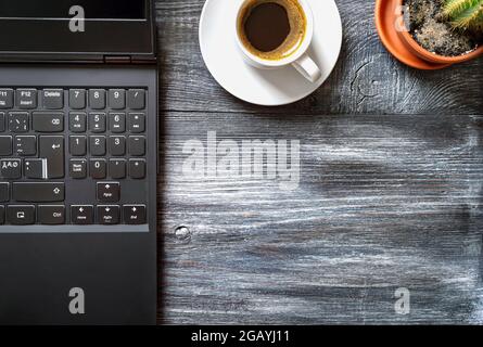 Workplace with laptop, cup of coffee, cactus on a wooden table, top view, flat lay with copy space. Work at home. Online Education. Stock Photo